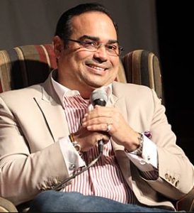 Gilberto Santa Rosa sitting with microphone.