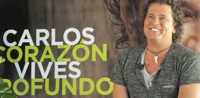 Carlos Vives in front of Corazon Profundo poster