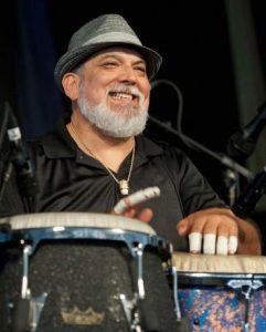 Poncho Sanchez smiling and playing Latin Jazz