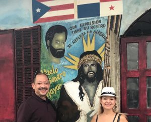 Hector Aviles and Ivonne Bruno in front of Sorolo's place mural of Ismael Rivera and the Cristo Negro.
